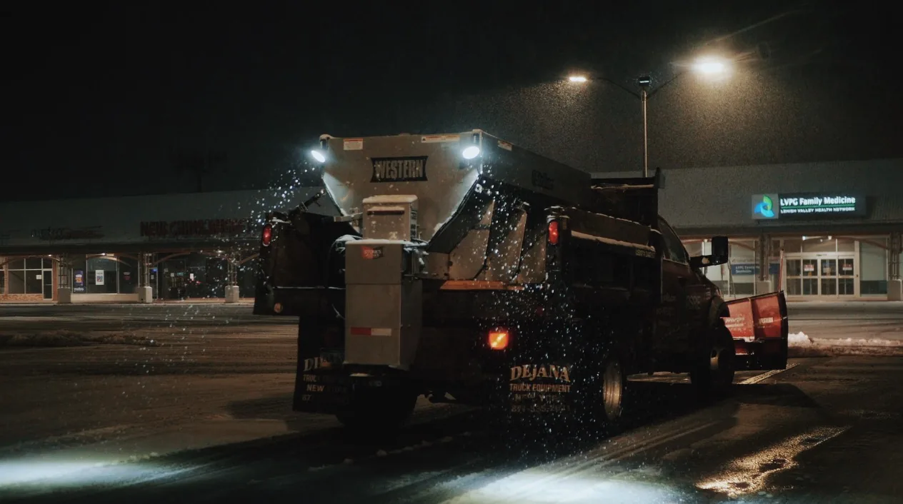 Professionals Salting & De-Icing a Parking Lot