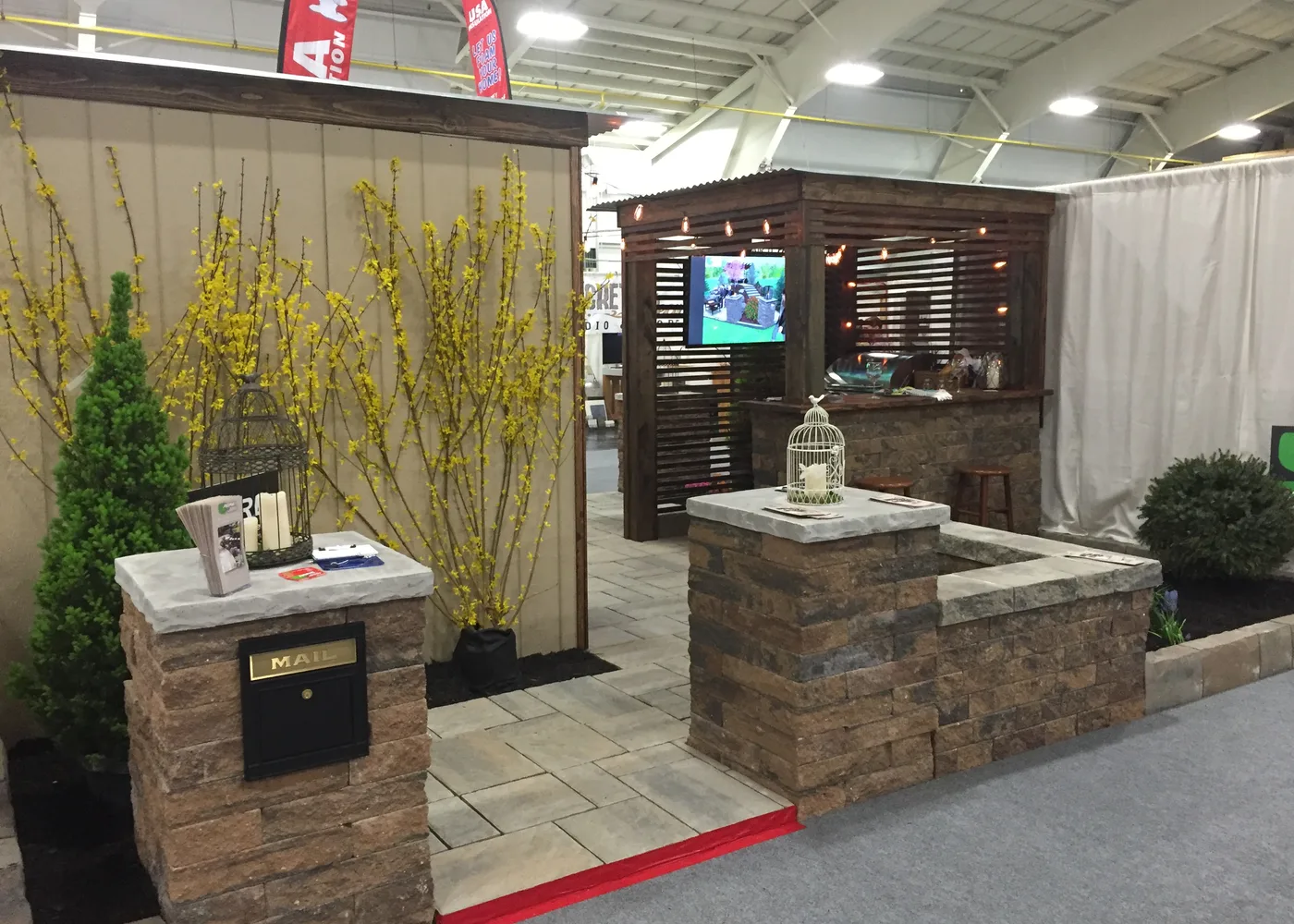 ASRE outdoor living display with stone pillars and plantings